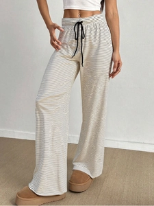 Detail of high waist elastic waistband with drawstring on striped wide leg trousers