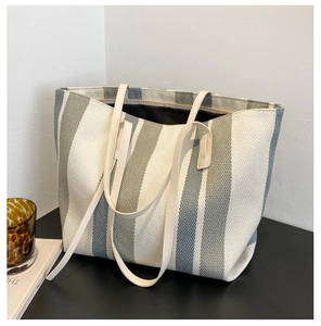 Detail of grey and white striped canvas tote bag showing thick woven fabric and straps