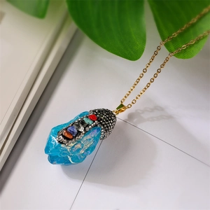 Detail of blue crystal pendant with colorful chakra stones and golden chain