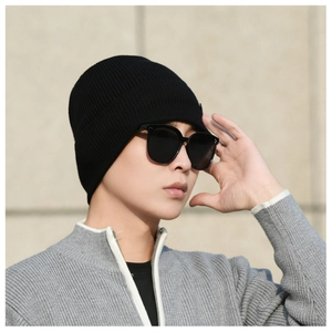 Detail view of a black knitted beanie with a premium ribbed texture and warm fleece lining
