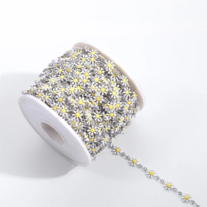 Macro detail of daisy flower chain links with white and yellow enamel for DIY jewelry