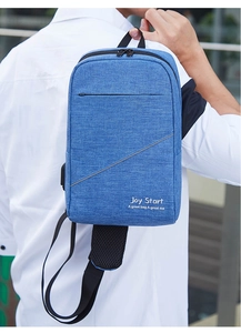 Rückansicht einer blauen Oxford-Brusttasche mit Joy Start-Stickerei am Modell