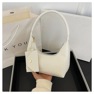 Detail of white moon-shaped woven texture handbag with matching coin purse and strap