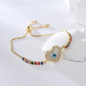 Adjustable golden heart slider bracelet with colorful gemstones and evil eye pendant