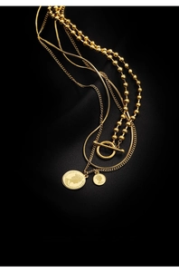 Close-up of triple-layered gold necklaces with portrait coin pendants and OT toggle clasp