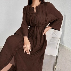 Detail of chocolate brown pleated V-neck dress featuring button-front and matching waist belt