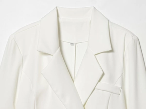 Detail shot of white blazer notched lapel with decorative chest pocket and size S label