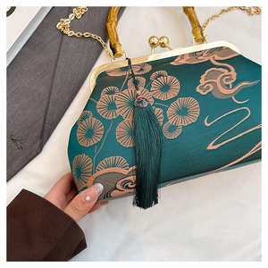 Detailaufnahme der dunkelgrünen Satin-Sticktasche mit Bambusgriff und goldener Kette