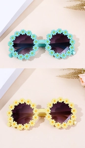 Detailed view of daisy flower accents on blue and yellow round kids sunglasses