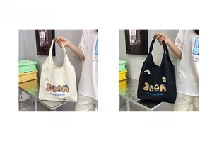 Detailaufnahme der Canvas-Tasche mit BOOM FASHION Schriftzug und Cartoon-Patches