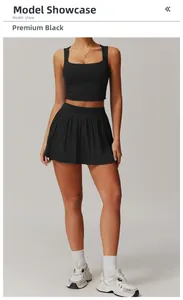 Front view of black two-piece sports set with crop top and pleated fitness skirt
