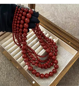 Détail des colliers de perles rouge foncé à cinq rangs avec fermoirs en métal argenté