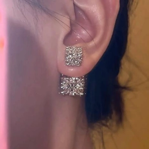 Close-up of sparkling square zircon stud earrings worn by a model with elegant style