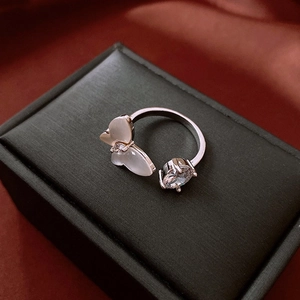 Detailed close-up of a silver butterfly open ring with zircon and opal on black velvet