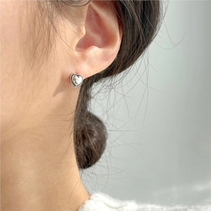Sterling silver heart stud earring with twisted rope detail on female model's ear