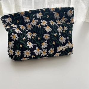 Close-up of daisy embroidery on black fabric showing fine texture and sewing detail