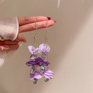 Detail of purple petal earrings with crystal drops worn for a French vintage look