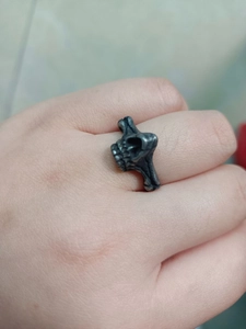 Detail shot of vintage punk style stainless steel skull ring worn on hand with silver finish