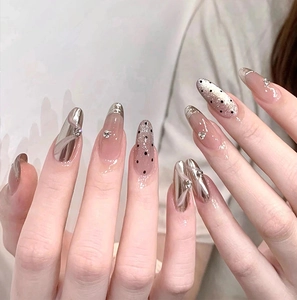 Detail of almond-shaped pink cat eye press-on nails with silver ribbon and rhinestones