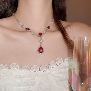 Dettaglio della collana d'argento con pendente di gemma rossa e strass su un modello