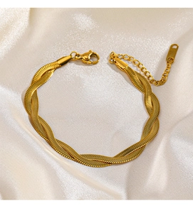 Detail of 18K gold-plated twisted snake chain bracelet on elegant white silk fabric