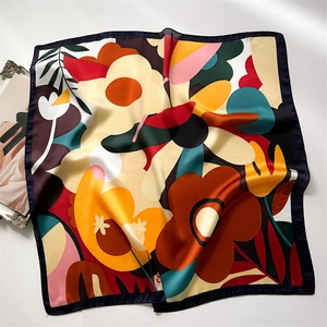 Detail of vibrant floral print on silk-like satin square scarf with fine black edges