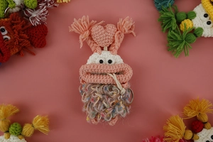 Macro shot of handmade crochet monster key cover with pink body and colorful tassels