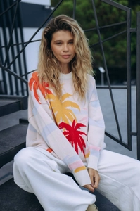 Detailed close-up of colorful palm tree jacquard on white knit sweater for women