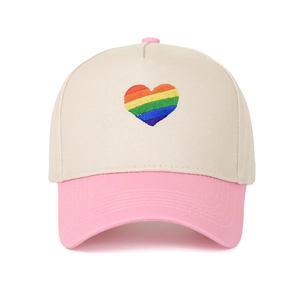 Cappello trucker crema e rosa con ricamo cuore arcobaleno in vista frontale centrata