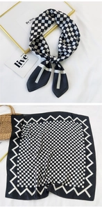 Close-up of black and white checkerboard silk scarf with stylish wavy edge pattern
