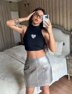 Detail of high waist silver metallic leather mini skirt with black heart halter top