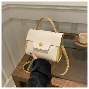 Detail of lychee pattern leather texture on cream and yellow two-tone crossbody bag