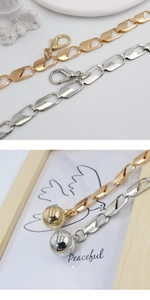 Detail of adjustable metal waist chain with geometric links and spherical pendant charms
