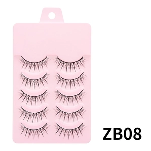 Detailed close-up of 5 pairs of natural criss-cross false eyelashes on a pink tray