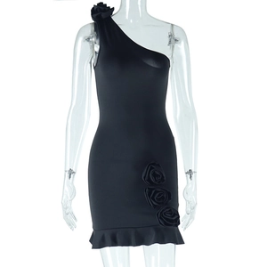 Detail of black one-shoulder dress featuring 3D rose accents and ruffled hemline