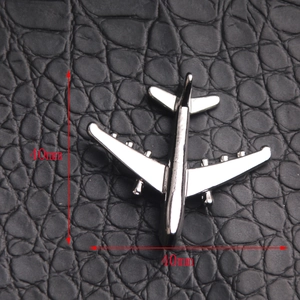 Detailed top view of 40mm silver airplane pendant on black leather background