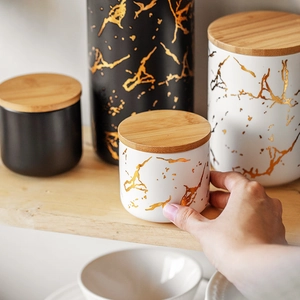 Nordic ceramic storage jars with marble patterns, bamboo lids and gold accents