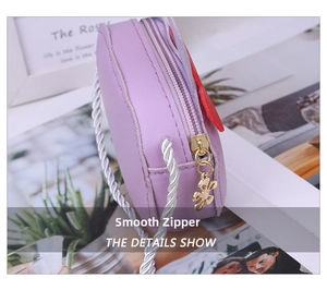 Close-up of children purple leather crossbody bag with golden butterfly zipper and braided strap
