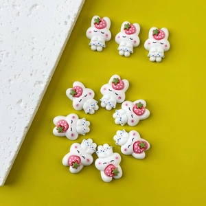 Flat lay of nine cute resin white rabbits holding red strawberries on a yellow background