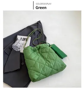 Dettaglio della borsa tote verde trapuntata con tracolla a catena e pochette coordinata