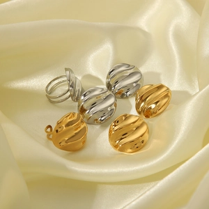 Irregular wavy round 18K gold and silver stainless steel rings on satin background