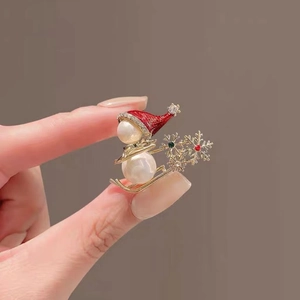Detail of Christmas snowman brooch with pearls, red enamel hat and rhinestone snowflake