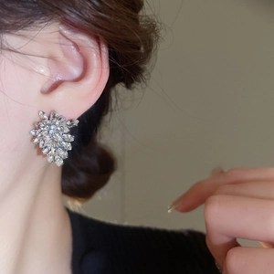 Close-up of sparkling crystal leaf stud earring worn on model for an elegant look