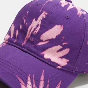 Gros plan détaillé de la texture en coton tie-dye violet et des coutures de la casquette