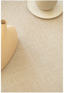 Detailed top-down view of beige textured carpet fabric with elegant weaving patterns