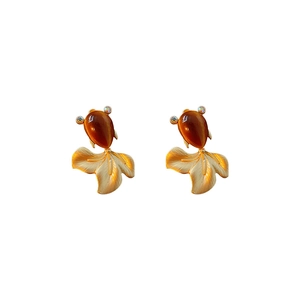 Vintage gold fish earrings with amber resin water drop and crystal accents on white base