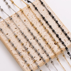 Retro stainless steel beaded chains in gold silver and black on stone texture