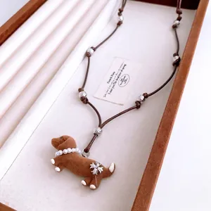 Brown dachshund dog pendant necklace with pearls and metallic beads on a leather rope