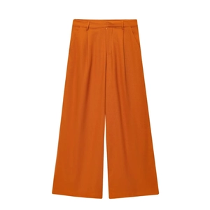 Détail du pantalon en lin orange à taille haute avec jambes larges et plis