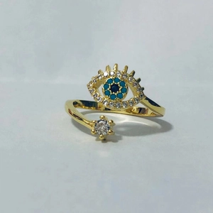 Detalle macro del anillo ojo turco dorado con cristales azules y circonitas blancas